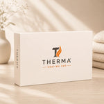Therma Heating Pad premium product packaging displayed on a warm minimalist tabletop with soft natural lighting, decorative vase, and cozy neutral home décor background.